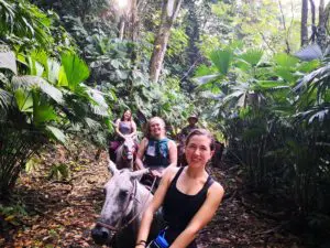 Group riding horses smiling at camera