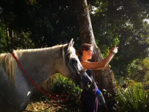 Horse and woman taking a photo of the horizon